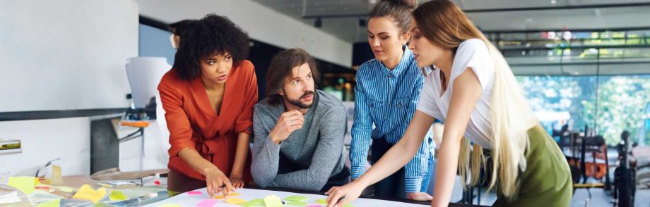 Time de profissionais discutindo ideias de um projeto no escritório da empresa e utilizando a metodologia ágil.